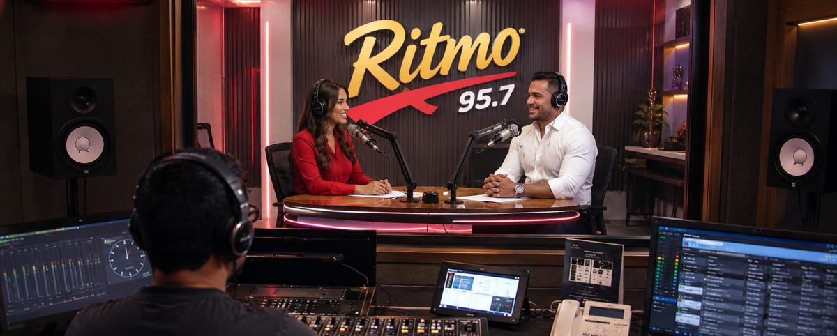 Entrevista en estudio de radio con invitado y operador de audio.