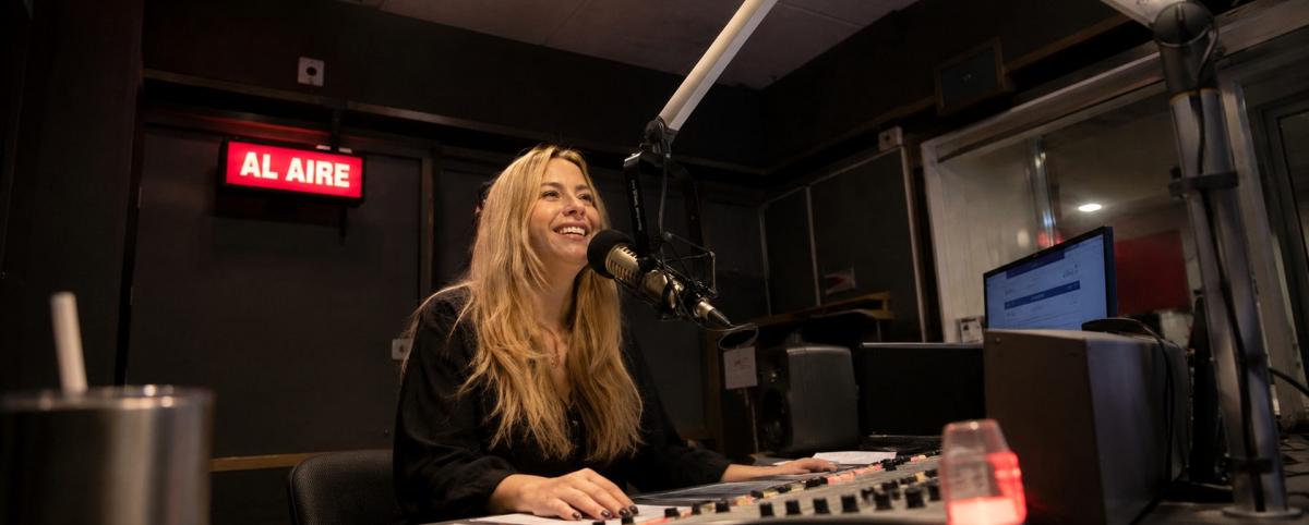 Locutora transmitiendo en cabina profesional de radio